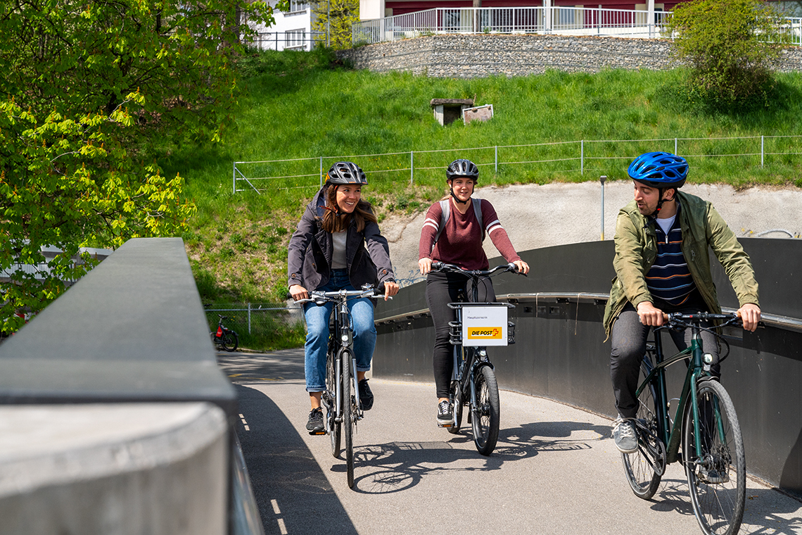 3 persone in bicicletta su un ponte ciclabile
