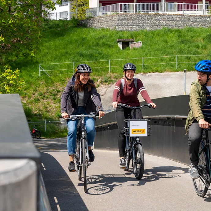 3 persone in bicicletta su un ponte ciclabile